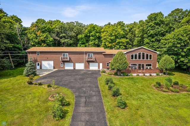 view of front of house featuring driveway, a front yard, and a wooden deck