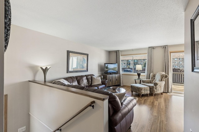 living area with a textured ceiling and wood finished floors