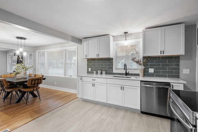 kitchen with stainless steel appliances, white cabinets, and light countertops