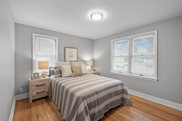 bedroom with wood finished floors and baseboards