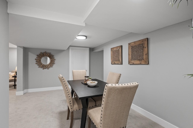 dining area featuring light colored carpet and baseboards