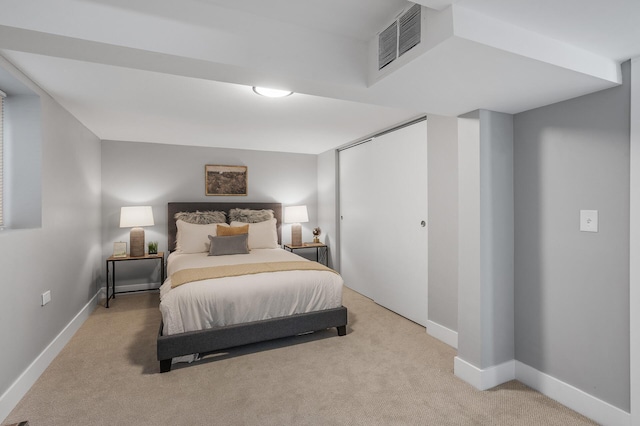 bedroom with light carpet, baseboards, visible vents, and a closet