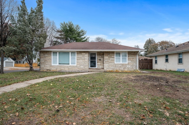 ranch-style house featuring a front yard, stone siding, roof with shingles, and fence