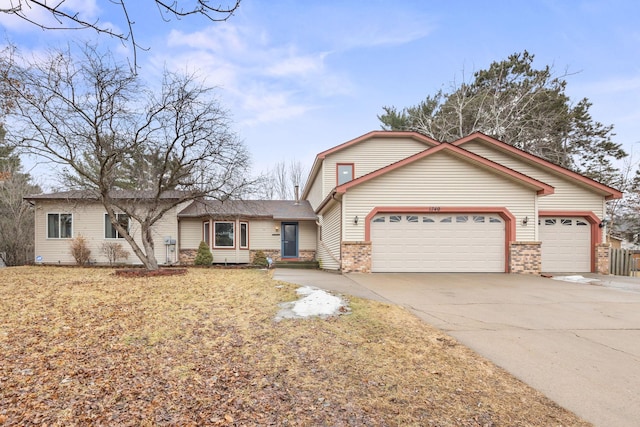 view of front facade featuring a garage, brick siding, and driveway