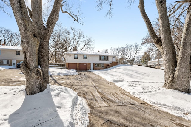 view of front facade with driveway, a garage, and brick siding