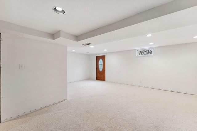 below grade area featuring light carpet, visible vents, and recessed lighting