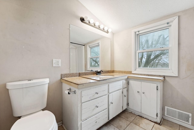 bathroom featuring visible vents, toilet, a textured ceiling, vanity, and tile patterned flooring