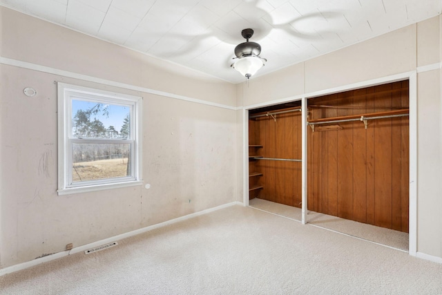 unfurnished bedroom with carpet floors, a closet, visible vents, and baseboards