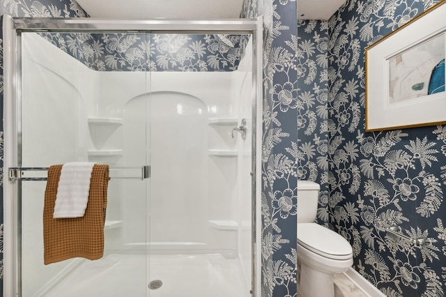 full bathroom with a shower stall, toilet, and wallpapered walls