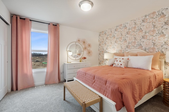 bedroom with wallpapered walls, visible vents, and light colored carpet