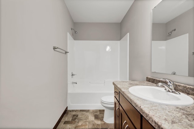 full bath with toilet, vanity, bathing tub / shower combination, baseboards, and stone finish floor