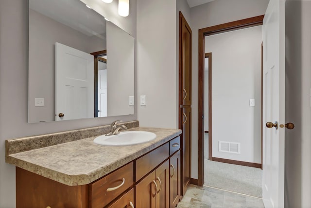 bathroom featuring vanity, visible vents, and baseboards