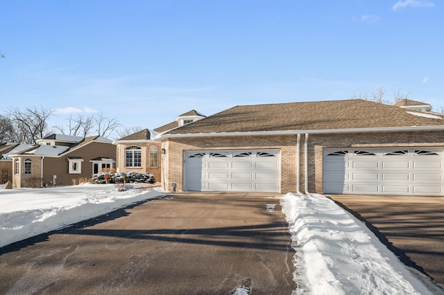 view of front of home with a shingled roof, concrete driveway, brick siding, and an attached garage