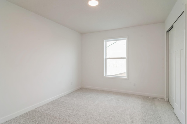 unfurnished bedroom with baseboards and light colored carpet