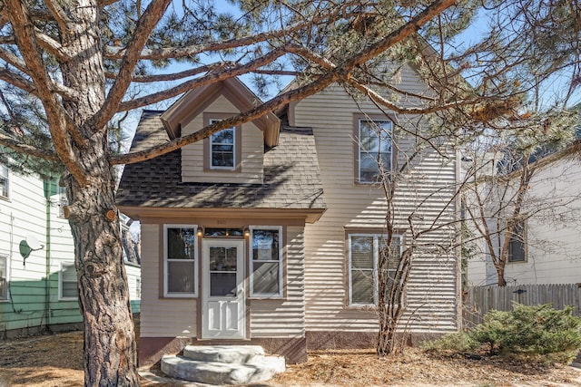 view of front of house featuring fence, roof with shingles, and entry steps