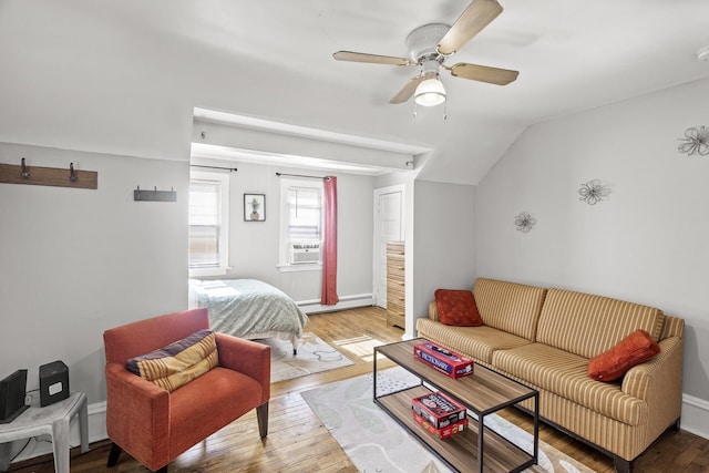 bedroom with hardwood / wood-style flooring, a baseboard heating unit, cooling unit, lofted ceiling, and ceiling fan