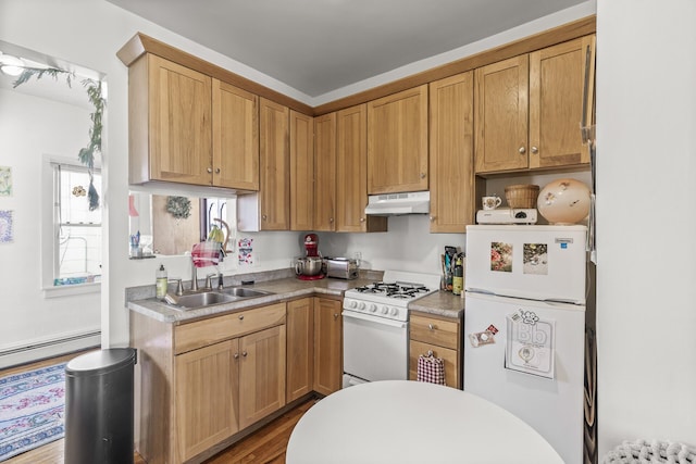 kitchen featuring white appliances, a baseboard radiator, a sink, light countertops, and under cabinet range hood