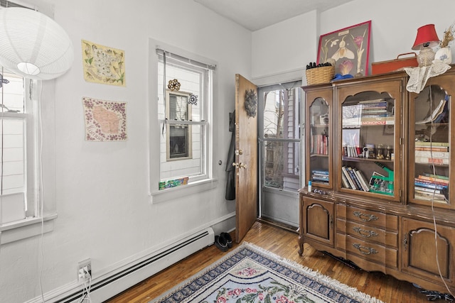 entryway featuring a baseboard heating unit and wood finished floors