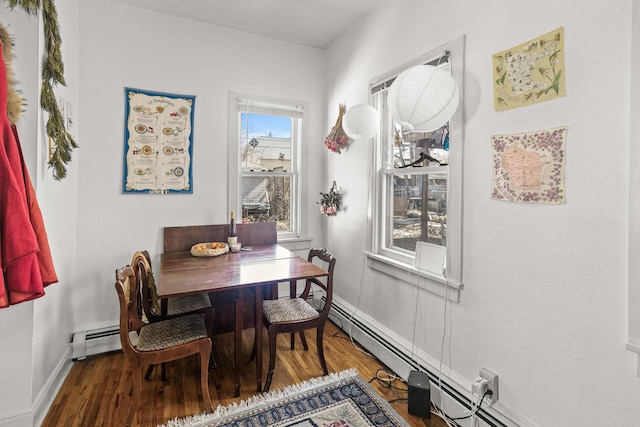 dining space with baseboards, baseboard heating, and wood finished floors