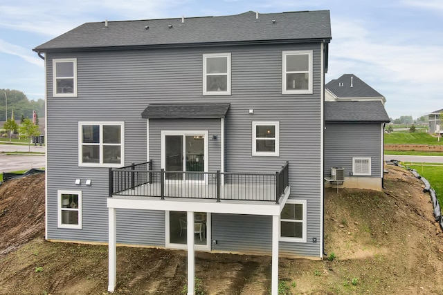 back of house with a shingled roof and central AC