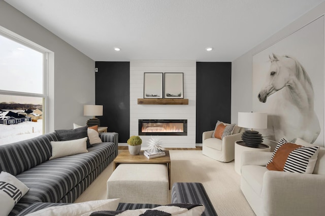 living area featuring a large fireplace, wood finished floors, and recessed lighting