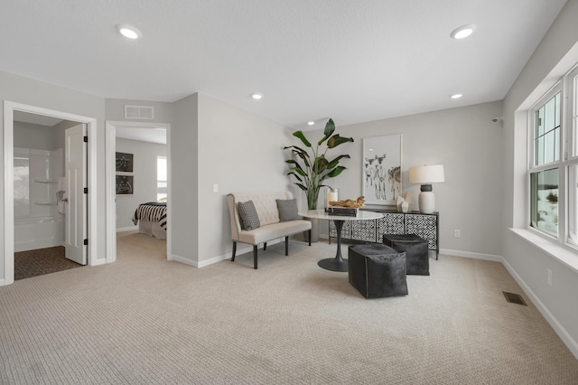 sitting room with a healthy amount of sunlight, carpet, visible vents, and baseboards