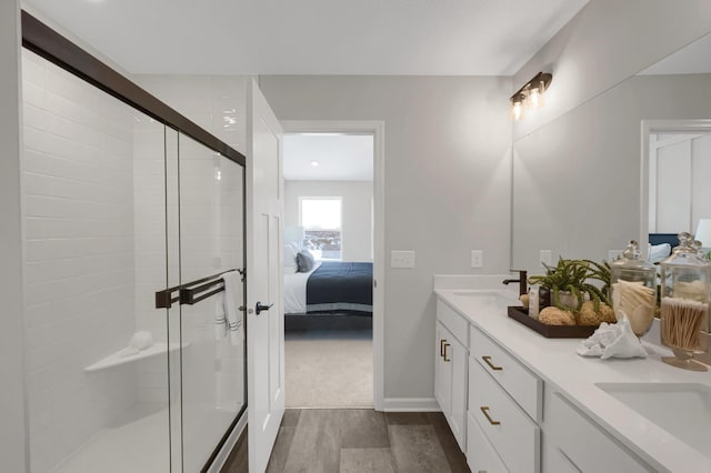 ensuite bathroom with ensuite bathroom, double vanity, a sink, and a shower stall