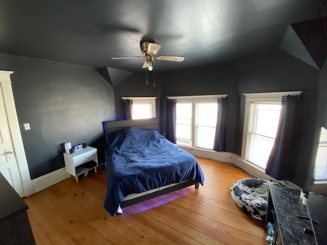 bedroom featuring baseboards, ceiling fan, vaulted ceiling, and light wood finished floors