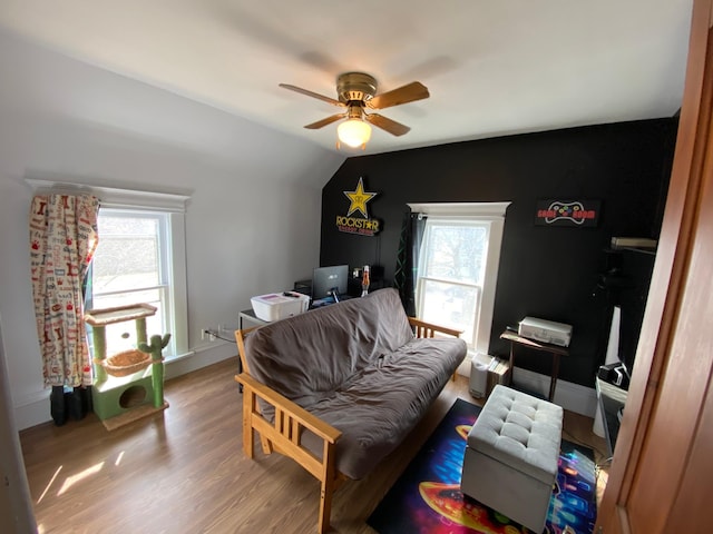 bedroom featuring multiple windows, ceiling fan, lofted ceiling, and wood finished floors