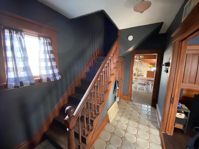 stairway featuring visible vents and baseboards