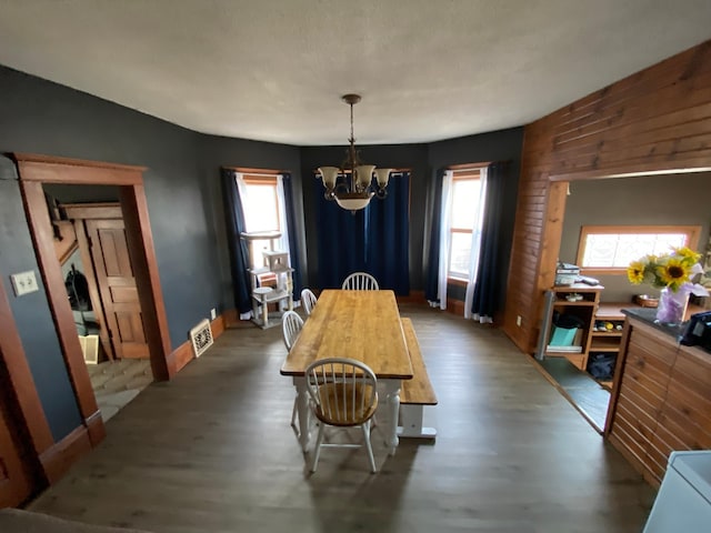 dining room with a chandelier, a healthy amount of sunlight, and wood finished floors