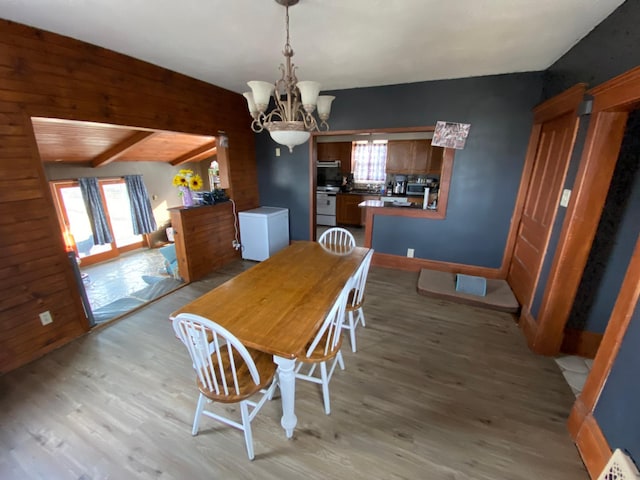 dining area with visible vents, beam ceiling, a chandelier, and light wood finished floors