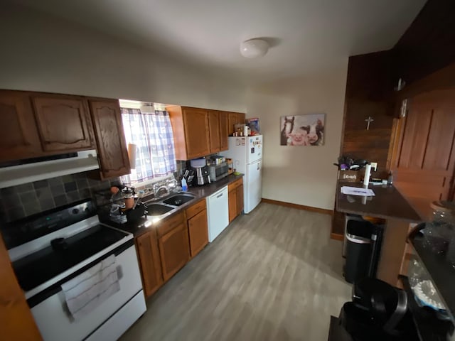 kitchen featuring white appliances, light wood finished floors, range hood, and backsplash