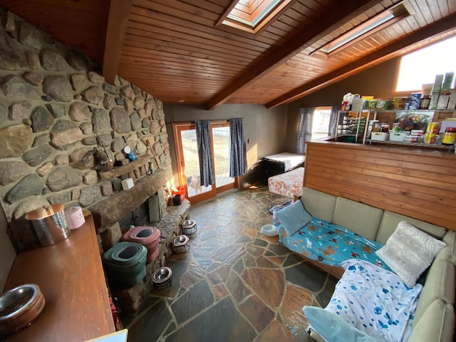 interior space with wooden ceiling, vaulted ceiling with skylight, and stone floors