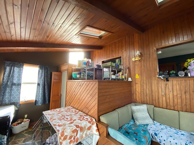 bedroom with lofted ceiling with skylight, wooden walls, and wooden ceiling