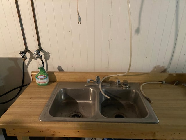 details featuring wooden walls, butcher block counters, and a sink