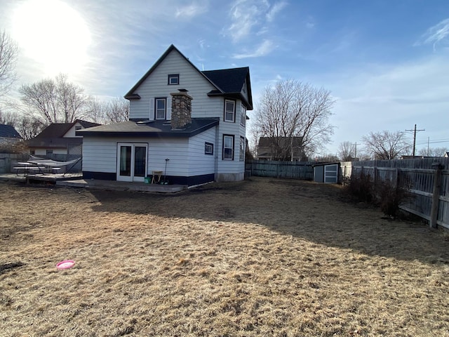 rear view of house with french doors and a fenced backyard