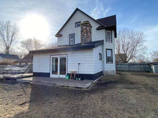 rear view of house with a deck and fence