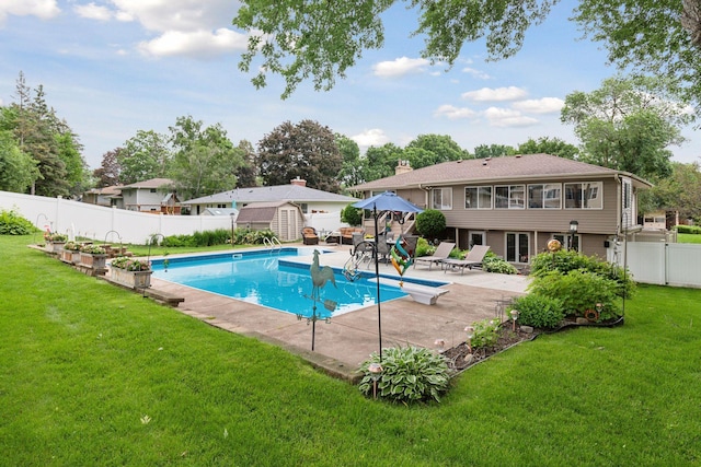 view of pool featuring a fenced in pool, a lawn, a fenced backyard, a patio area, and a diving board