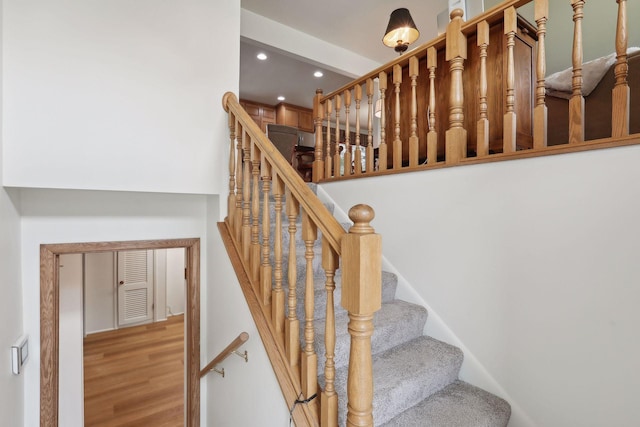 stairway featuring wood finished floors and recessed lighting