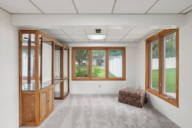 carpeted spare room featuring a paneled ceiling and visible vents