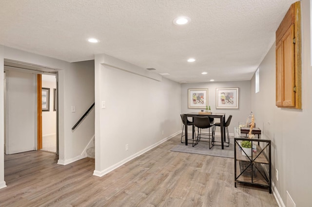 interior space with recessed lighting, a textured ceiling, baseboards, and light wood-style floors