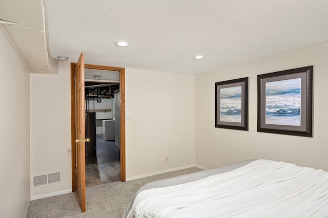 bedroom with baseboards, visible vents, a textured ceiling, and carpet