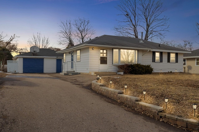 ranch-style home featuring entry steps, an outdoor structure, and driveway