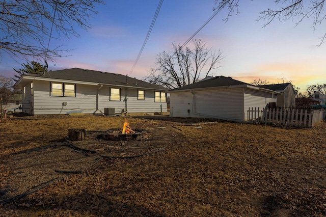 view of front of house featuring a fire pit, central AC, and fence