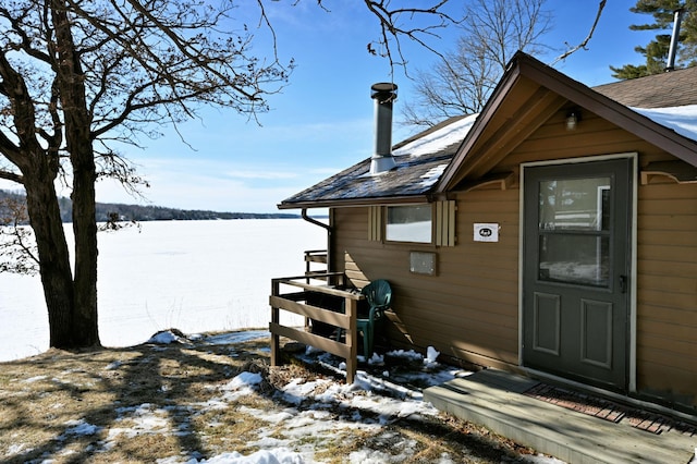 view of snow covered exterior with a shingled roof