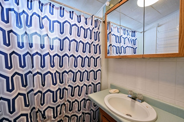 full bath with tasteful backsplash, a shower with curtain, tile walls, and vanity