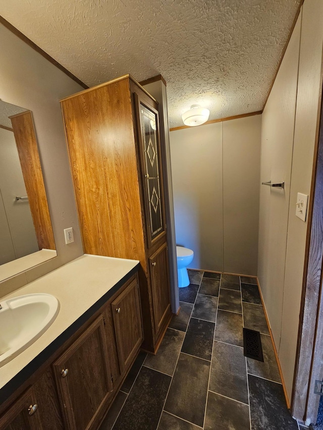 5 Orleans Ave, Inver Grove Heights, MN 55076 - bathroom with vanity, toilet, a textured ceiling, and ornamental molding