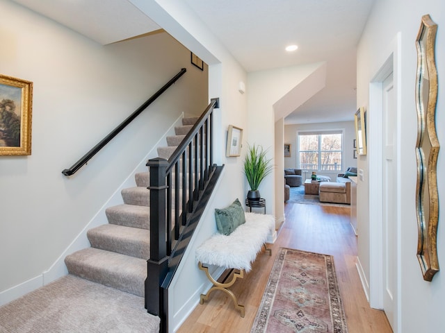 stairs featuring recessed lighting, baseboards, and wood finished floors