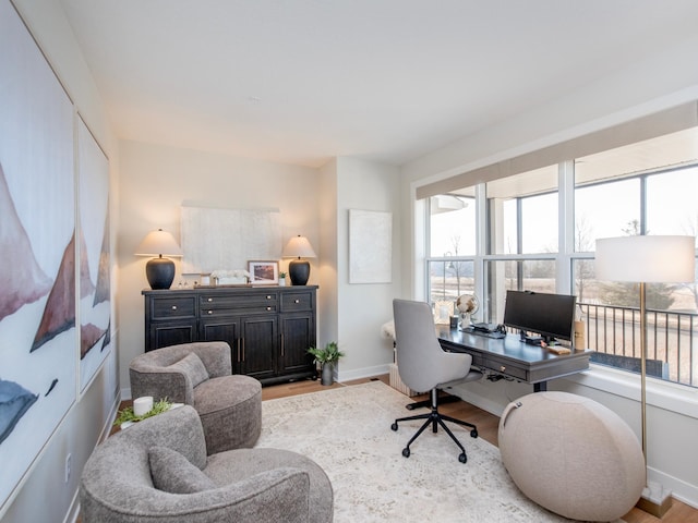 home office with baseboards and wood finished floors